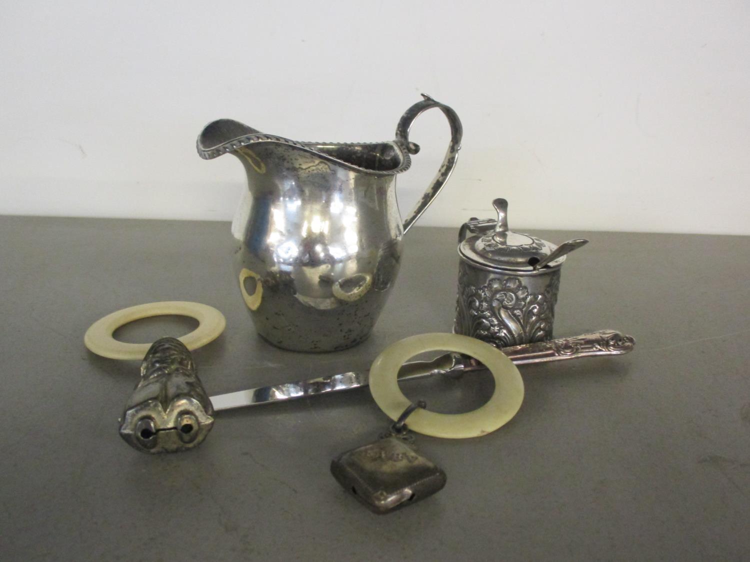 A mixed lot of silver items to include a milk jug and mustard pot and babies rattles.Location:Port