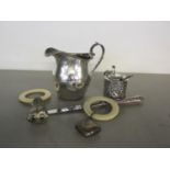A mixed lot of silver items to include a milk jug and mustard pot and babies rattles.Location:Port