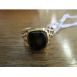 A 9ct gold ring set with a black onyx plaque, total weight 2.4g