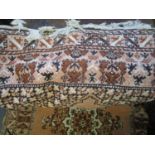 A Middle Eastern pale terracotta and floral pattern, hand woven rug with braided tassel ends, 92"