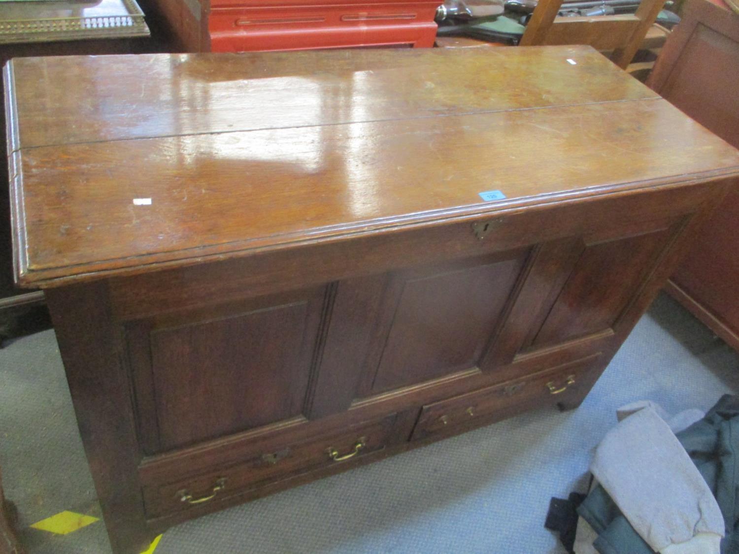 An 18th century oak panelled coffer having a hinged top and two drawers, 32 1/4"h x 50"w Location: