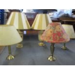 A pair of cream painted lamps and three metal lamp bases, each with shades