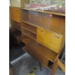 A mid 20th century teak display cabinet having sliding doors, shelves and drawers, standing on