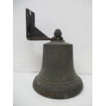 A government issue ships bell stamped SCC 9.61 above an arrow, on a black painted steel bracket,