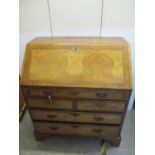 An 18th century walnut bureau with feather banding, a fall front, enclosing a fitted interior, above