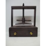 A 19th century mahogany book press with a planked frame, screw thread and turned handle, over a