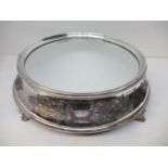 A Victorian silver plated cake stand with a mirrored top, a raised, bead edge, leaf and scrolled