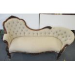 A Victorian walnut framed sofa with scrolled foliage ornament, part button upholstered in an oatmeal