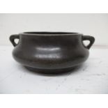 A Chinese, possibly Ming Dynasty bronze censer with twin loop handles and a six character mark to