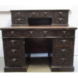 A late 19th century Angalo Chinese carved oak desk, profusely carved with dragons, clouds and