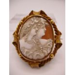 A Victorian yellow metal framed cameo brooch with oval shell cameo depicting two maidens with ornate