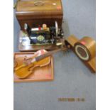 A Frister & Rosman sewing machine, a Smiths mantle clock, a violin and a tray