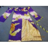 A heavily embroidered Japanese kimono having a purple ground with gold and silver thread, floral