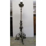 A Victorian wrought iron and brass standard lamp with a height adjustable column on a bulbous,