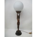 An Art Deco bronzed metal figural table lamp mounted on an ebonized pedestal base, in the form of