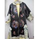 A Chinese black silk coat, late 19th/early 20th century having cream bordered cuffs and hems, hand