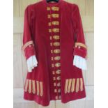 A theatrical red velvet coachman's jacket with gold coloured brocade and buttons, having cream