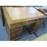 A Victorian oak twin pedestal desk having a leather topped scriber and nine drawers, 29 3/4" H x 42"