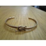 A yellow metal bracelet with knot design to the centre, 7.2g