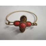 A 9ct yellow gold rope twist bracelet set with tigers eye and coral coloured stones in a cross