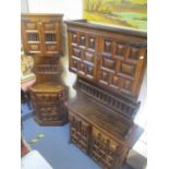 A reproduction oak dresser having two cupboard doors above a single shelf with drawers and cupboards