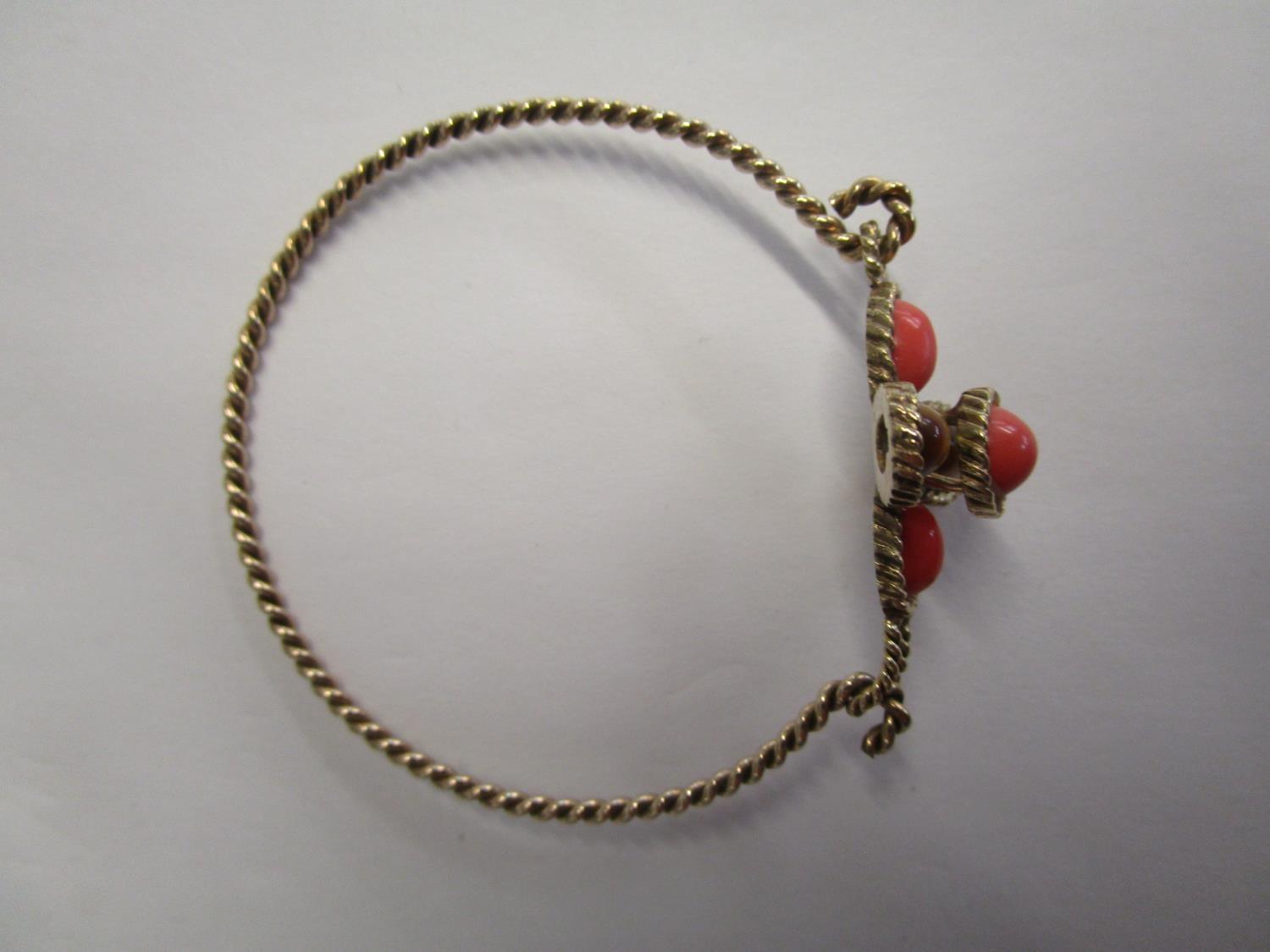 A 9ct yellow gold rope twist bracelet set with tigers eye and coral coloured stones in a cross - Image 2 of 2
