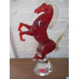 A Formia Murano red and gold glass sculpture of a prancing horse on a clear glass attached mount,