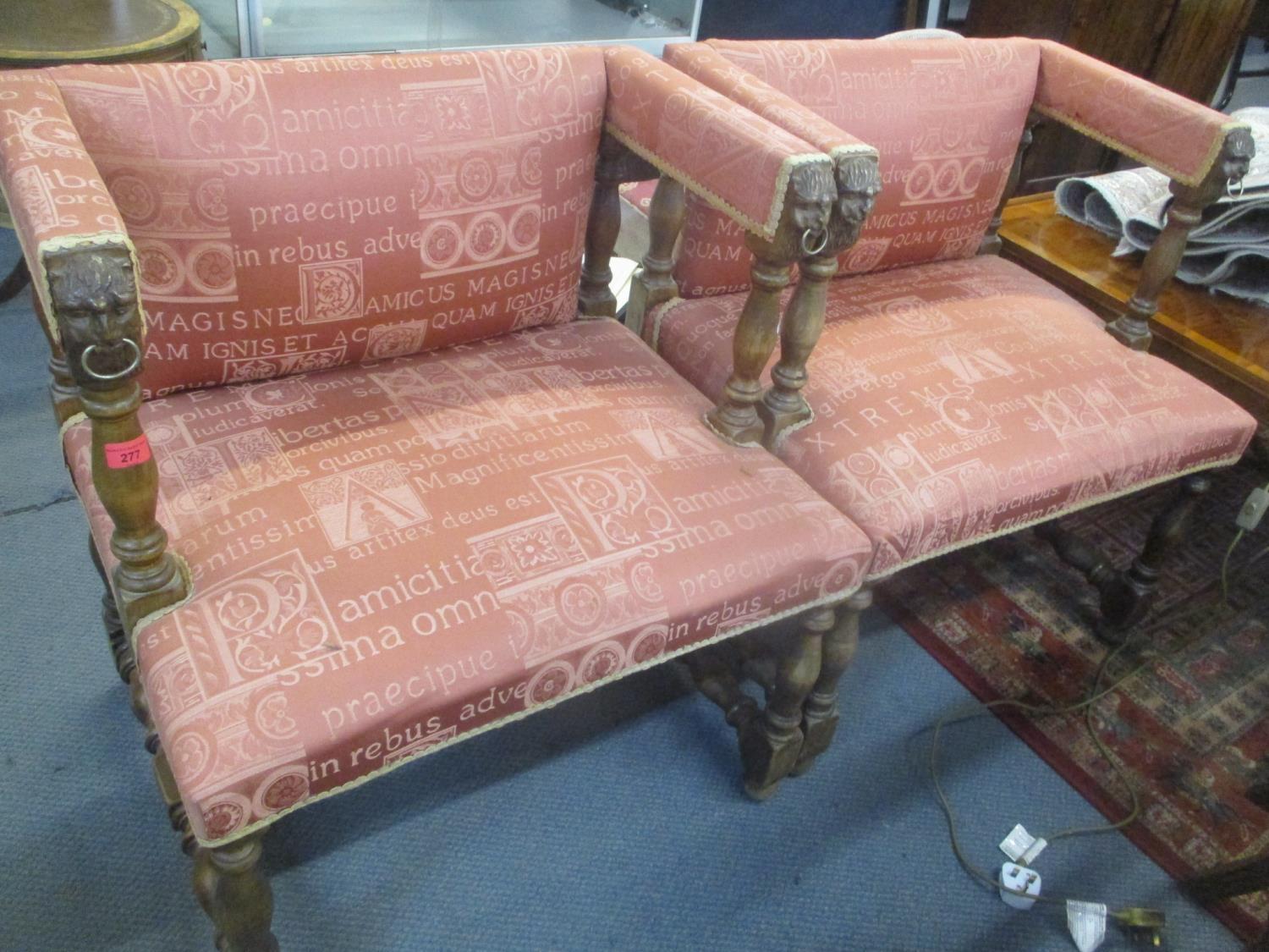 A pair of reproduction Empire style armchairs having carved mask and ring arms and H framed supports