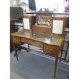 An Edwardian mahogany ladies writing desk having a swan neck pediment, two glass inkwells, leather