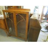 An early 20th century oak students bureau, together with a walnut display cabinet