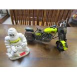 A painted cast metal model of a Michelin man and his dog and a metal model of a motorcycle