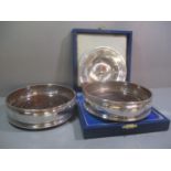 A pair of silver wine coasters, together with a small silver boxed dish