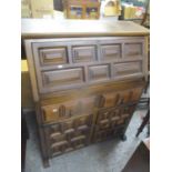 A reproduction oak finished bureau having a fall flap above two drawers and two cupboard doors 45