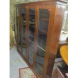 An early 20th century walnut large four door bookcase standing on a plinth base 72 1/2" W x 71 1/