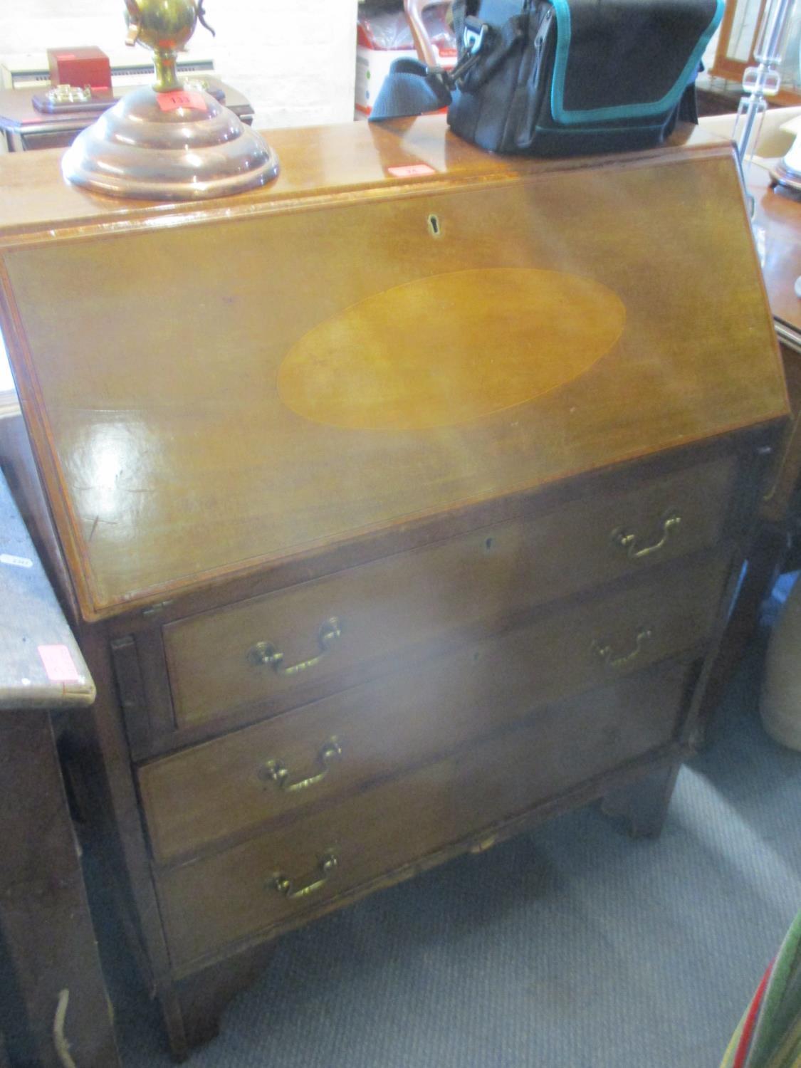 An Edwardian mahogany bureau having a fall flap above three drawers 38" H x 30" W