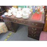 A Reproduction mahogany twin pedestal desk having a red leather top and nine drawers 30 1/2" H x
