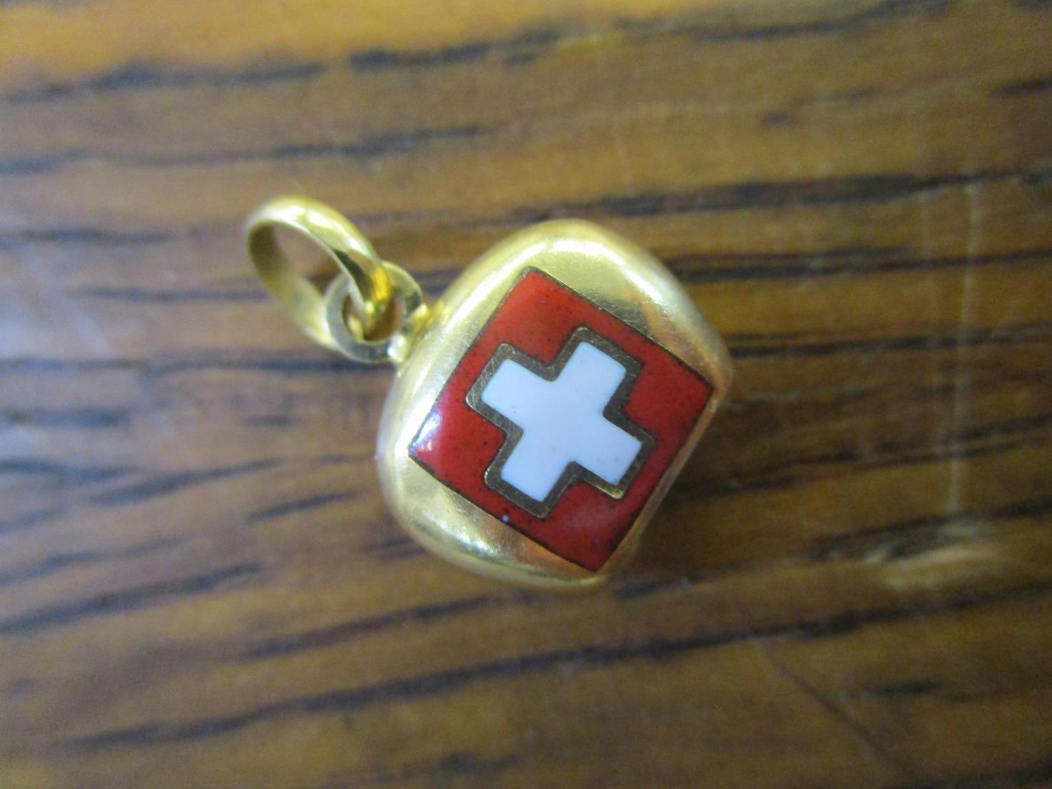 An 18ct yellow gold and enamelled Swiss charm in the form of a cow bell, 2.45g