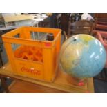 A vintage globe raised on a circular swivel base, together with a vintage Cola Cola crate