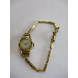 A gold plated ladies watch having an 18ct gold strap