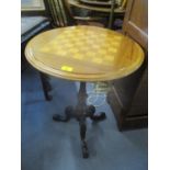 A Victorian circular topped games table on a mahogany carved tripod base 27 3/4" H x 21 3/4" W