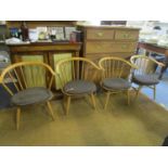 A set of four Ercol cow horn chairs with detachable brown cushion seats, model 2056, stamp marks