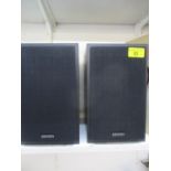A pair of small black Denon speakers 9 1/2" high