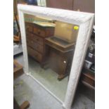 A large white painted mirror having a floral border and bevelled glass 53 1/4" H x 46 1/4" W