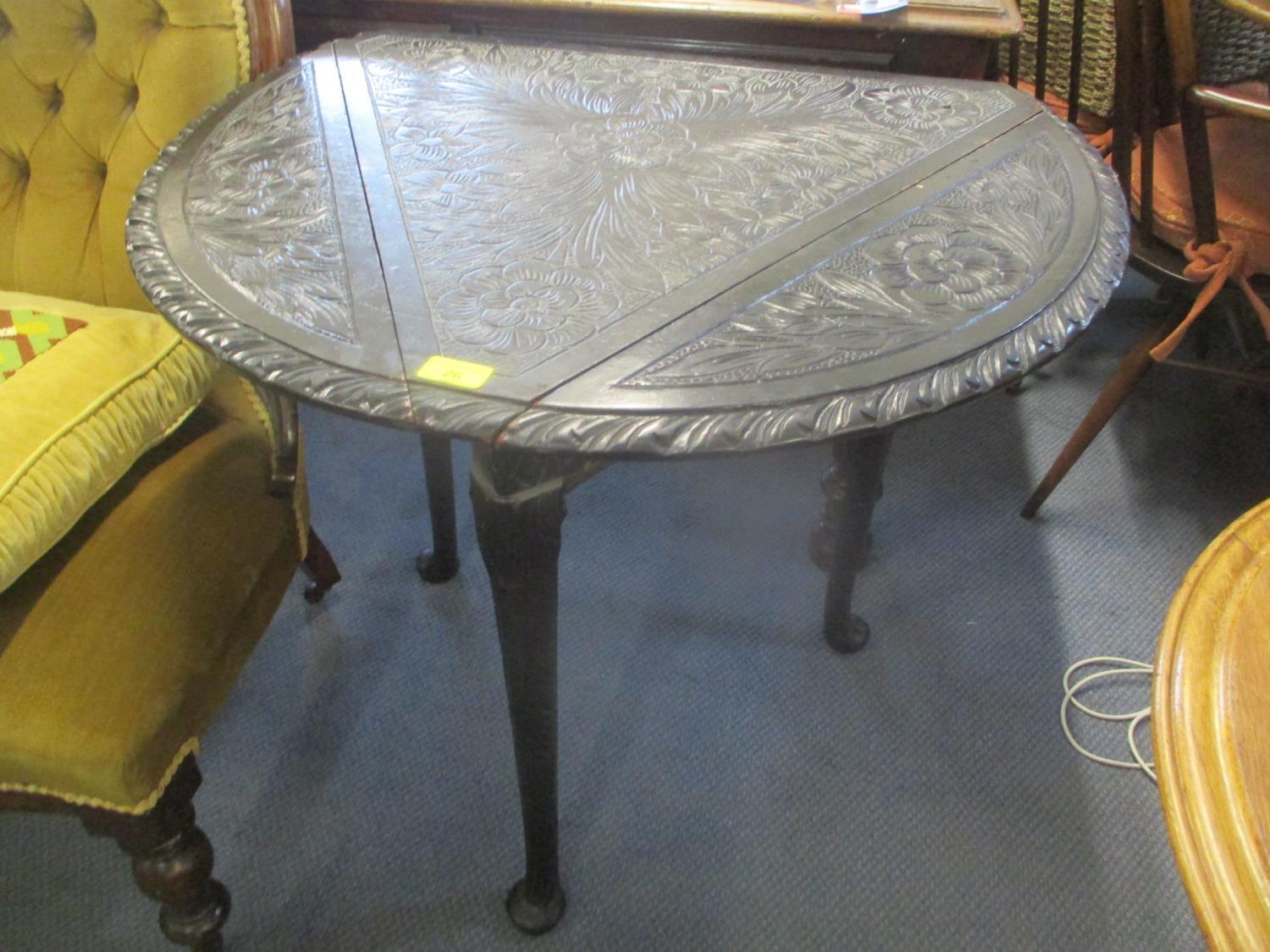 A late 19th century carved fall flap occasional table having four folding sides and on pad shaped