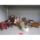 A quantity of dolls house furniture and dolls to include a wooden bed and piano, along with an early
