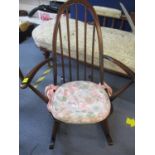 An Ercol dark stained child's rocking chair with pink floral cushion