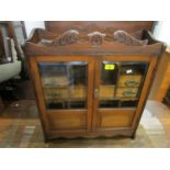 A late Victorian oak, wall hanging smokers cabinet with broken and leaf scrolled pediment, twin