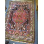 A Middle Eastern red ground rug having a central motif and multi-guard borders, 64" x 41"