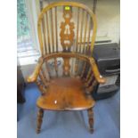 A 20th century Windsor elm seated chair having a pierced splat back and spindle supports