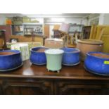 A group of ceramic planters to include four blue glazed bowls and stands